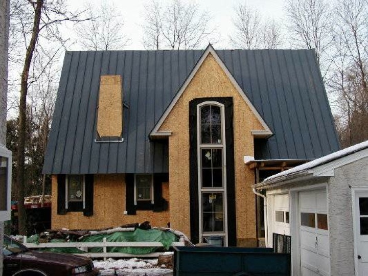 Home without siding that has a black metal roof