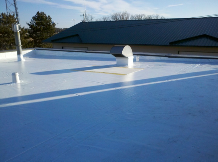 Ventilation duct exposed through a white roofing membrane