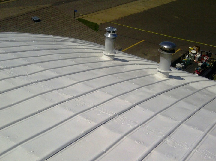 An arched roof with clean new white roofing
