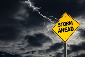 Storm Ahead warning sign against a dark cloudy and thunderous sky. 