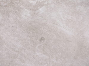 Small dent caused by hail in a flat roof with a circle drawn around it