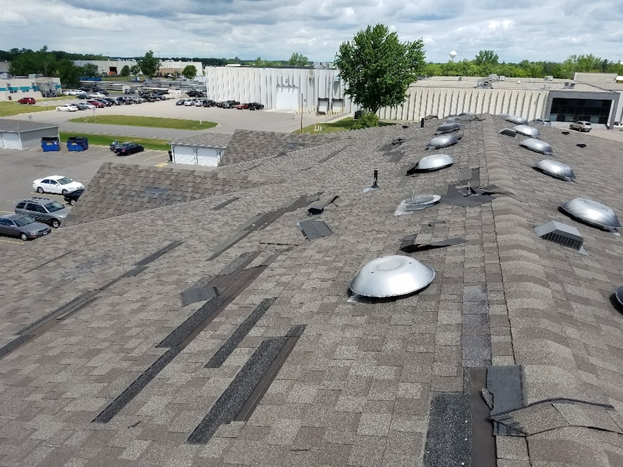 Asphalt shingle roof with many damaged and peeling shingles