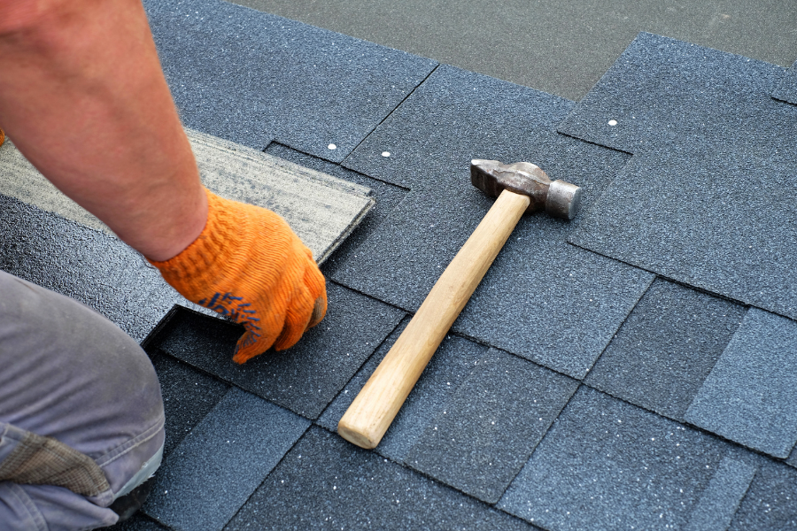 Roofer repatching a residential roof.