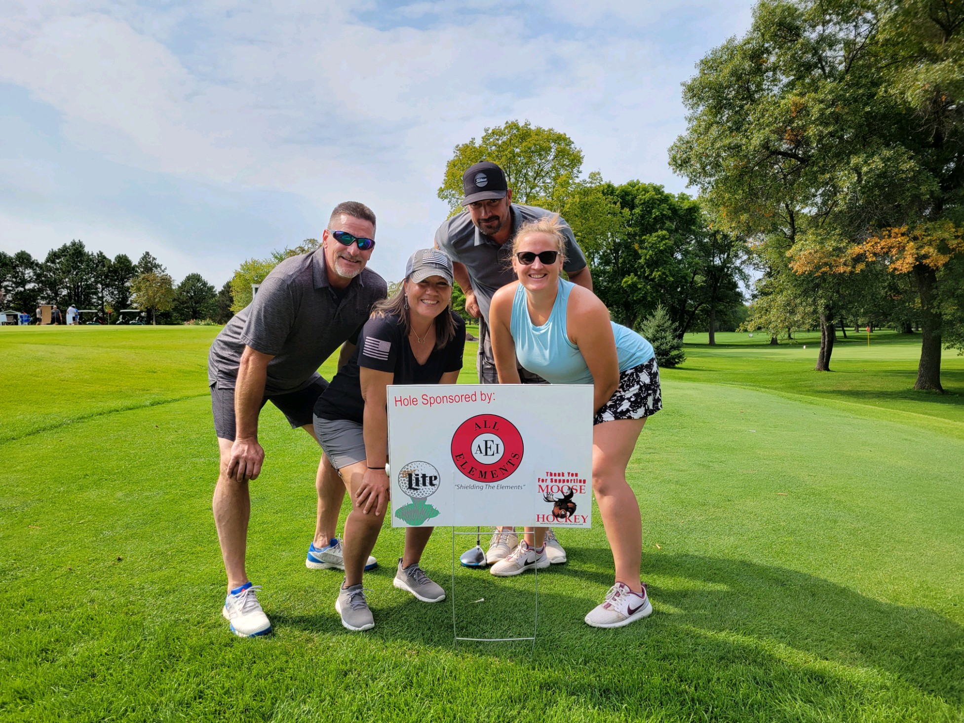 All Elements team standing near their sponsored gold hole