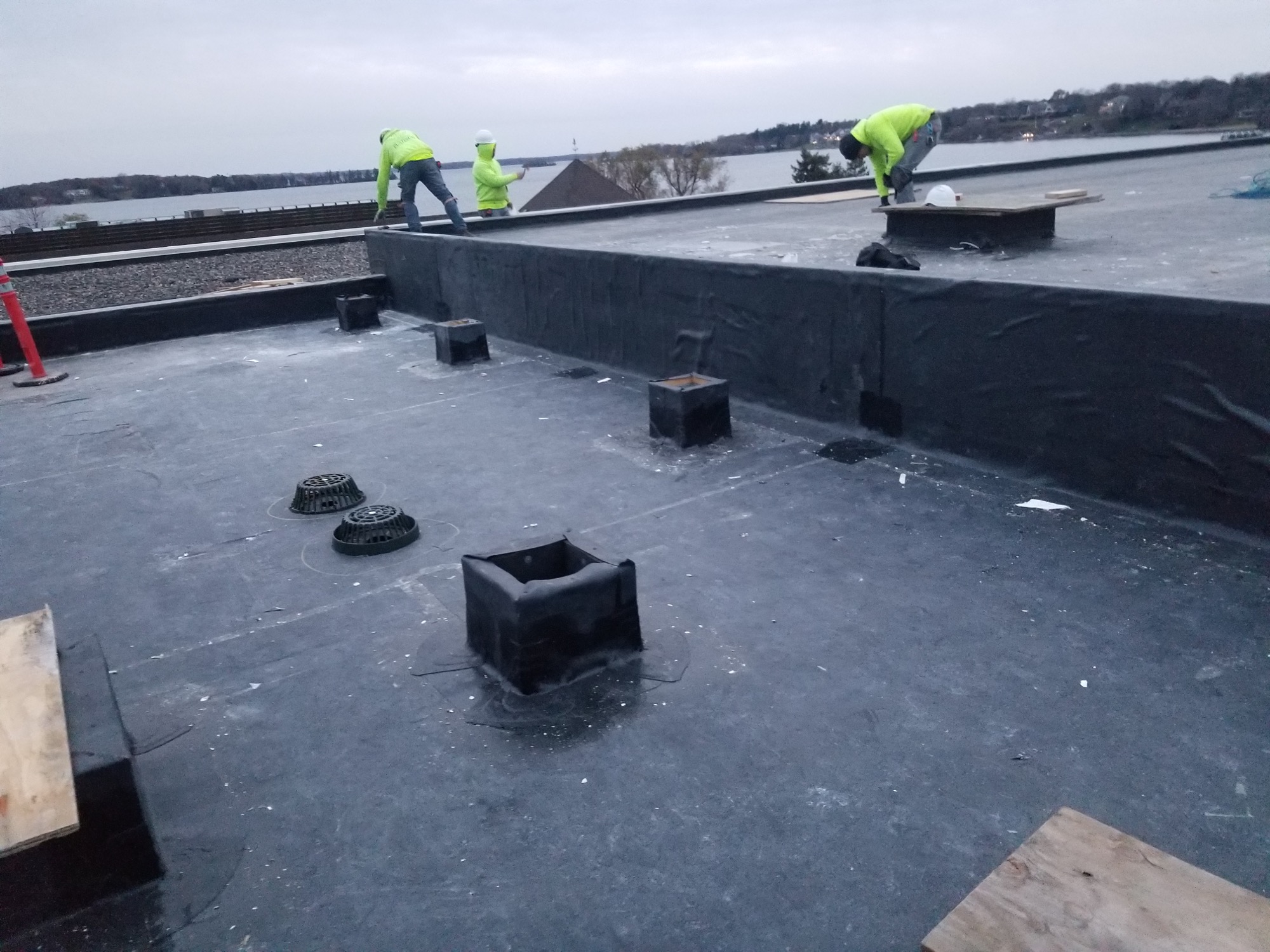 Roofers in bright yellow working on a flat roof