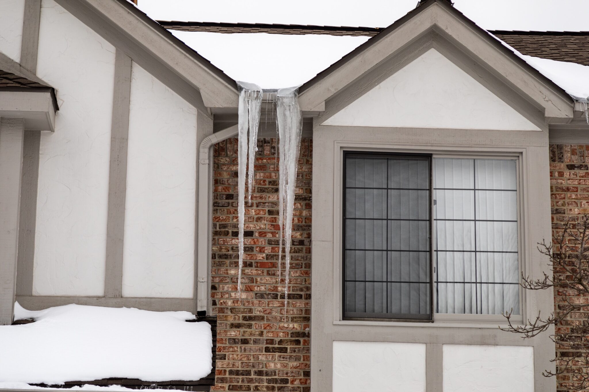 Long icicles hanging next to a home's window