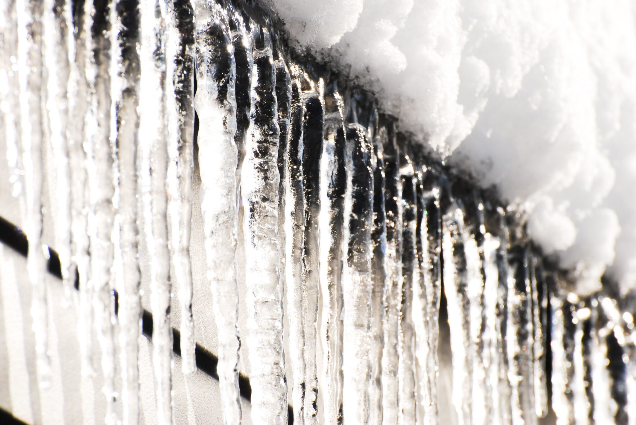 Icicles hanging from a snowy roof