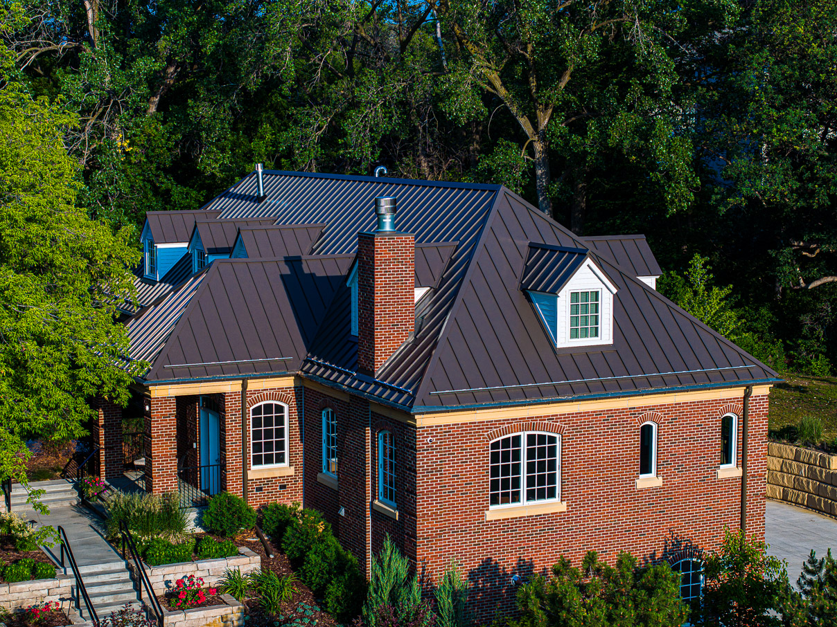 Large brick home with dark asphalt roofing shingles