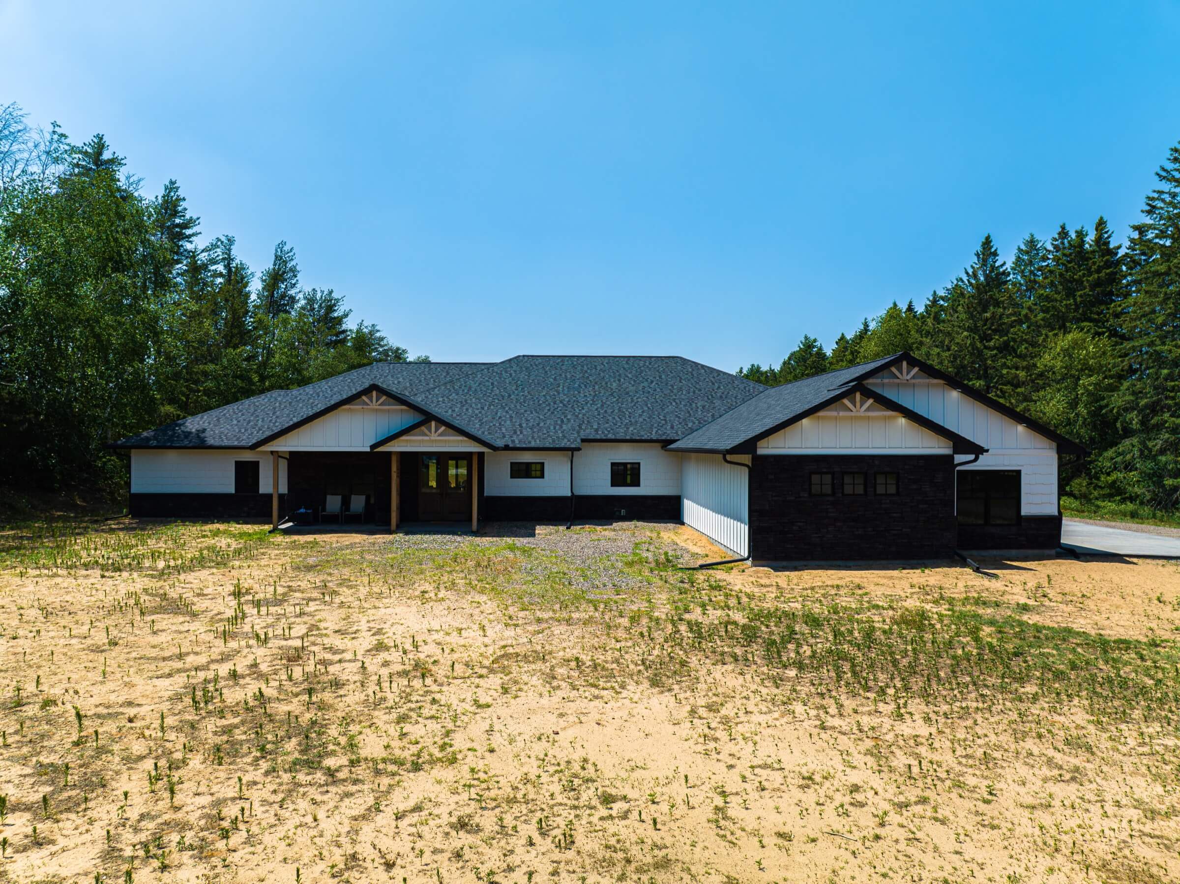 Newly built ranch house with dark asphalt roofing