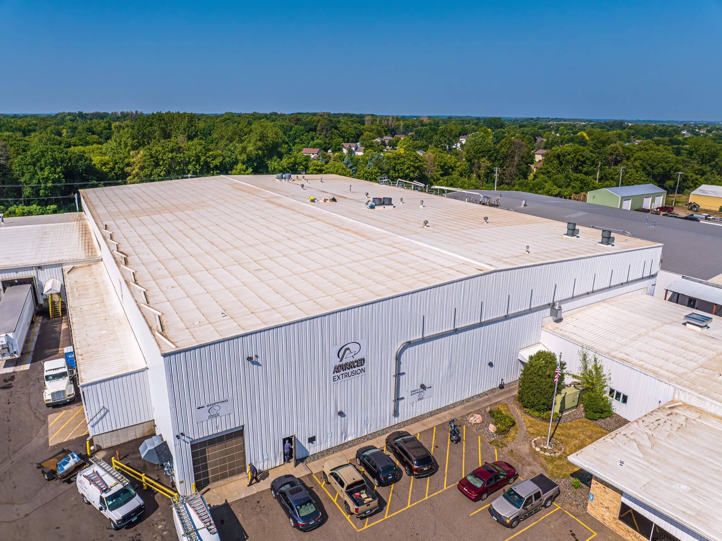 White factory building with brown stained roofing