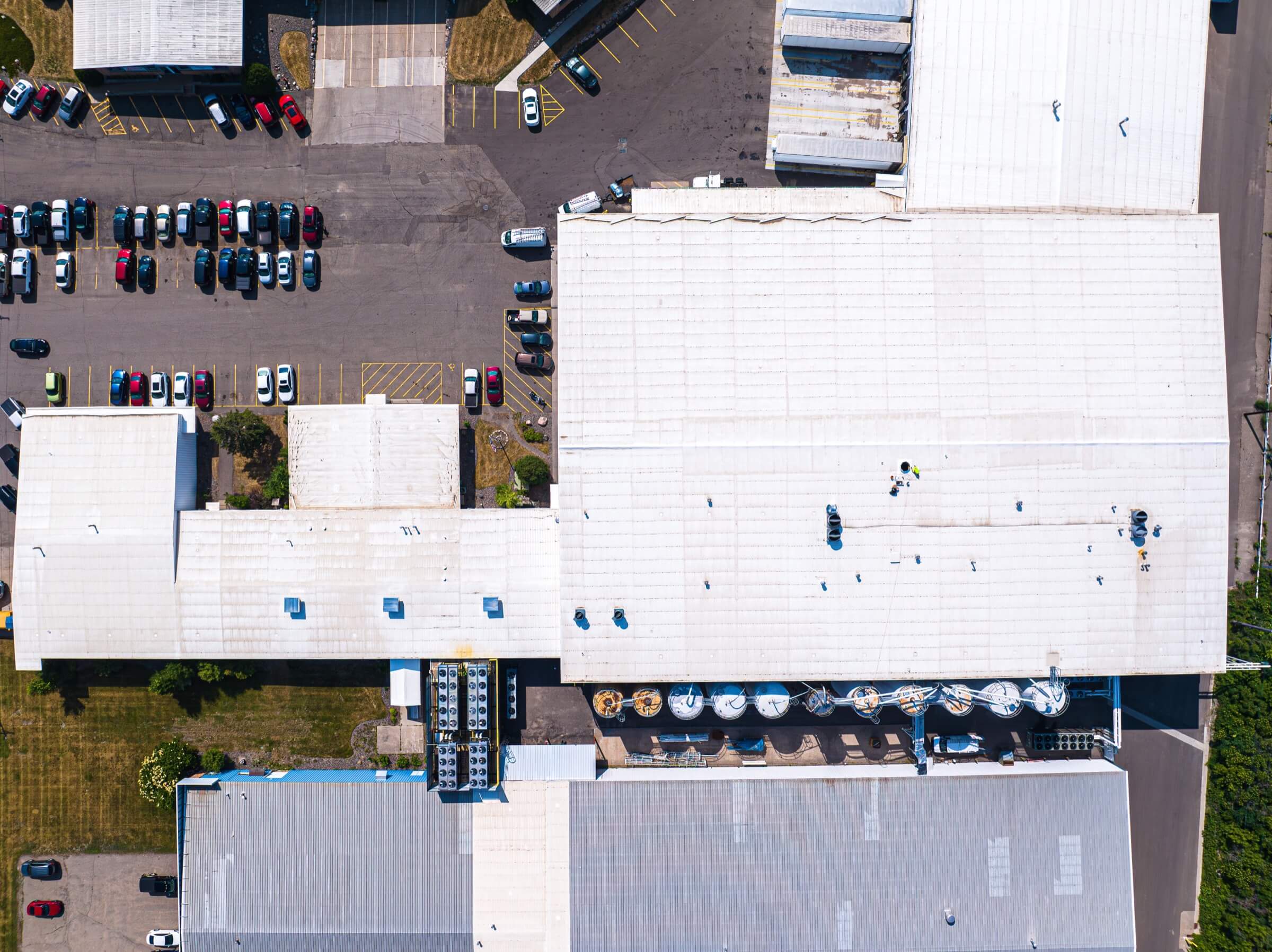 View looking down directly over a building's white industrial roof