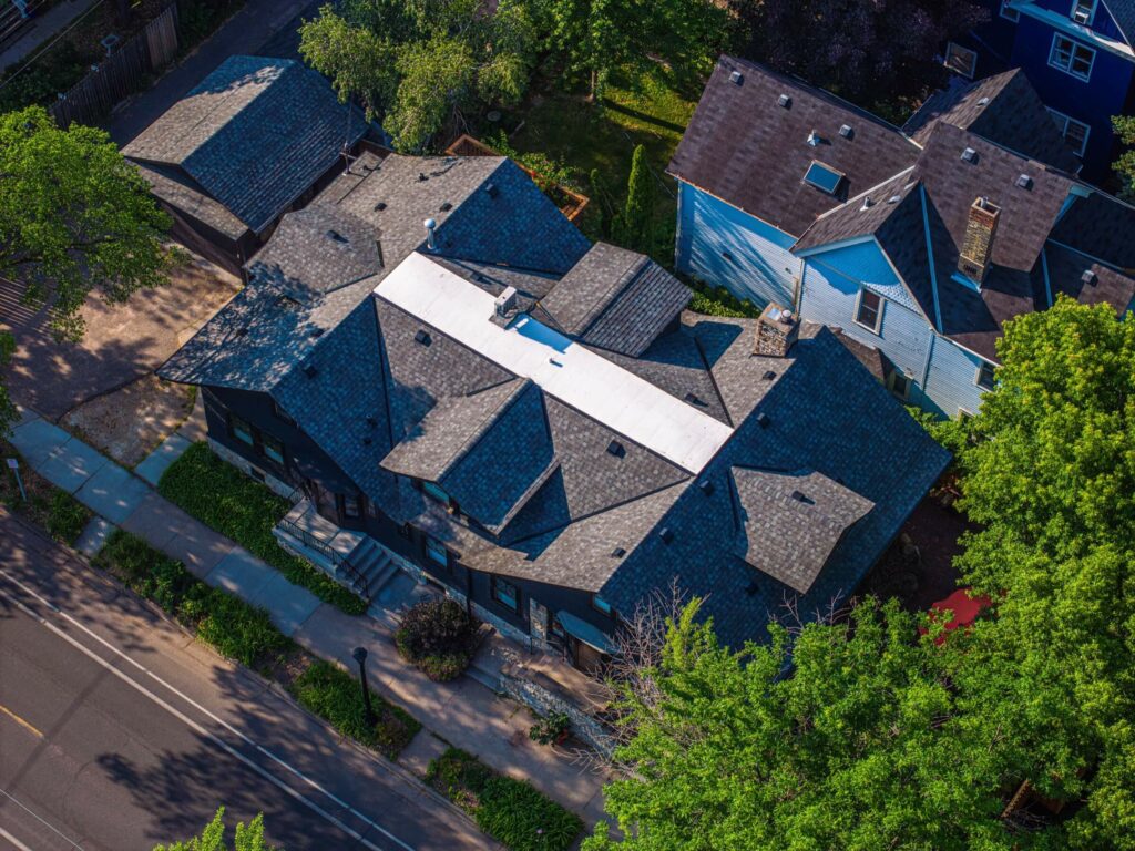 Aerial view showing an aged home's roof in a city